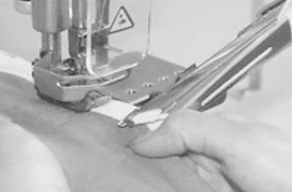 SF-1500-156M-UT — Garment handling at the compact sewing area, illustrated in the catalogue.